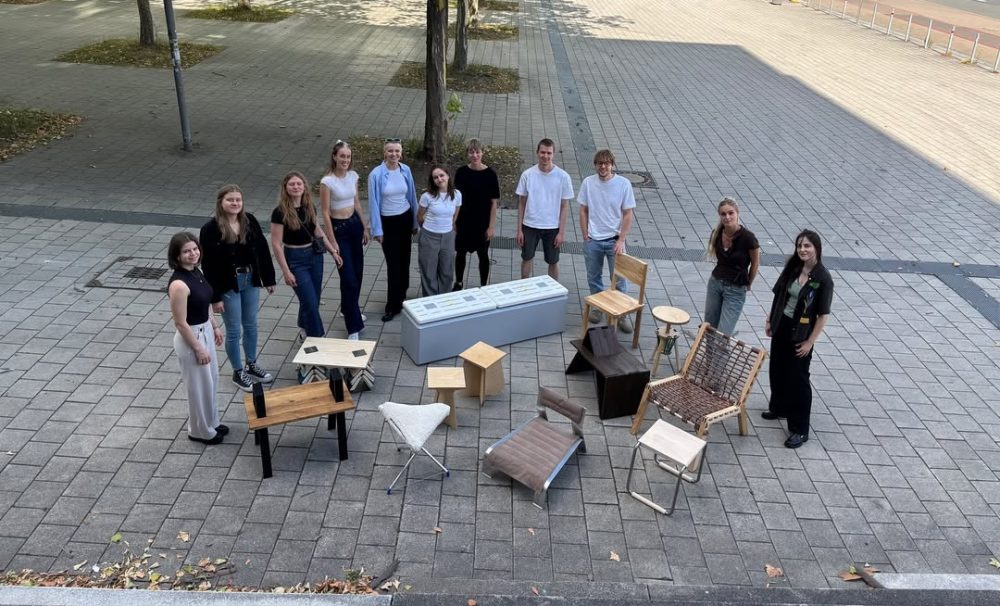 Gruppenfoto Menschen stehen vor Stühlen Carsten_Schelling_Entwurf 45_SoSe 2025
