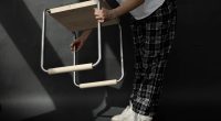 Mensch hebt Hocker hoch im Dunklen Raum Carsten_Schelling Entwurf 45 SoSe 2025 Bild: Pauline Wulkow