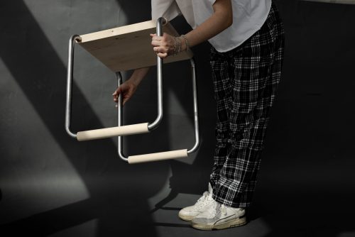 Mensch hebt Hocker hoch im Dunklen Raum Carsten_Schelling Entwurf 45 SoSe 2025 Bild: Pauline Wulkow