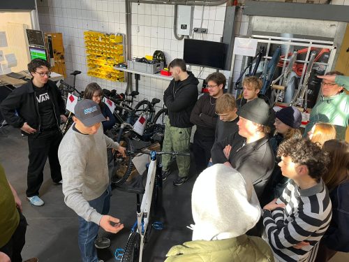 Gruppe steht vor einem Anschauungsmodel eines Fahrrad